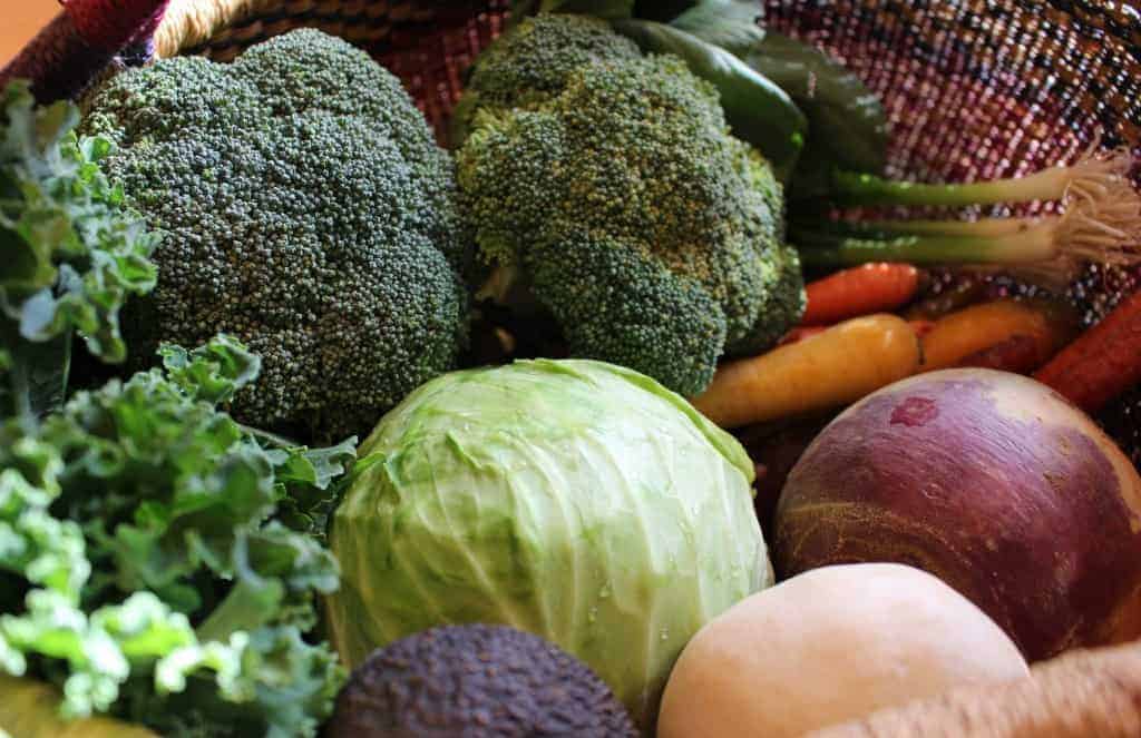 Fall veggies like kale, broccoli, cabbage and root veggies in a basket