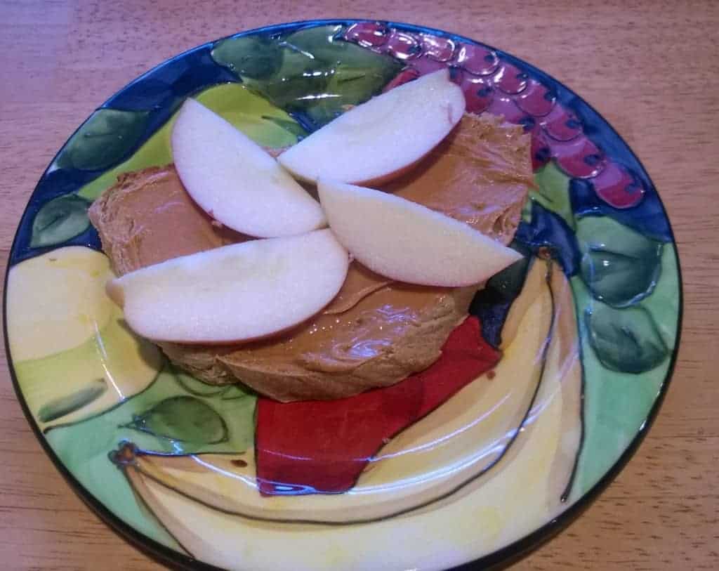 An open faced peanut butter sandwich with sliced apples